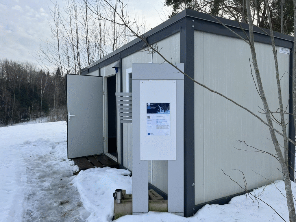 Jūrinis konteinerinis pastatas su informaciniu stendu